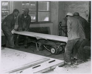 Workers moving the set concrete panels, circa 1960