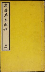 A yellow-bound, traditionally-stitched book with a vertical white label featuring Japanese calligraphy on the cover.